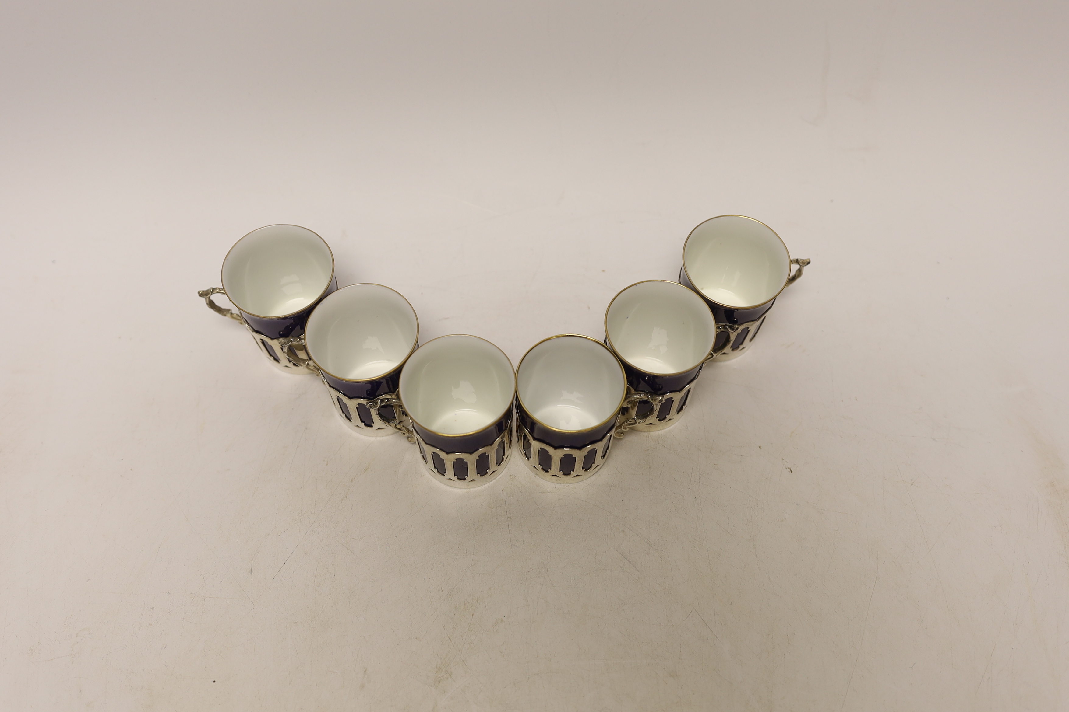 A set of six pierced silver handled coffee can holders, James Dixon & Sons, Sheffield, 1911, with six Crescent China coffee cans
